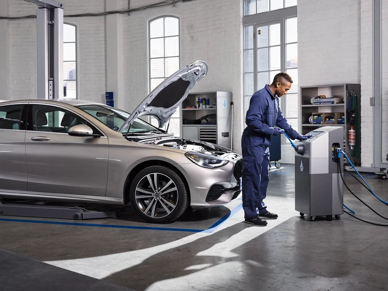 Helle Werkstatt mit geöffneter Motorhaube und vorbereiteter Klima-Servicestation